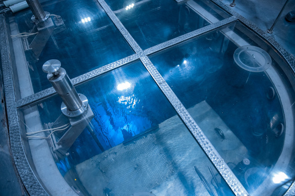 Água apresentando um brilho azul por conta da radiação em um núcleo de um reator nuclear.