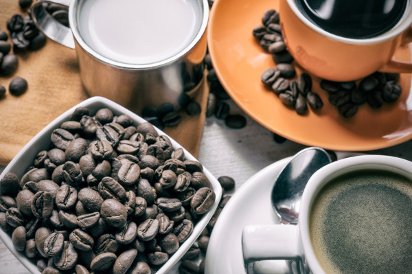 Café em grãos e xícaras com café