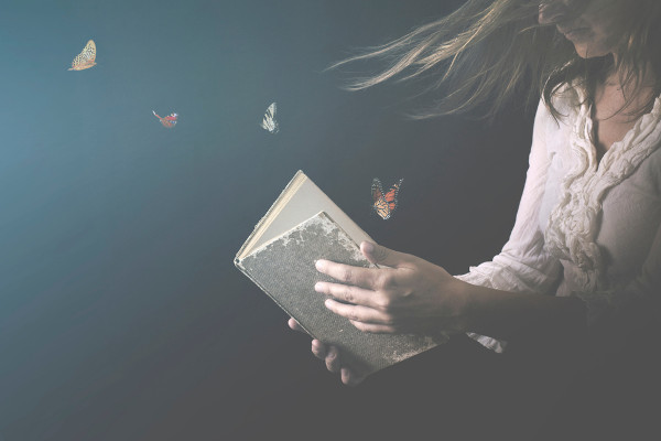 Mulher abre livro, de onde saem borboletas.