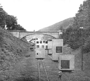 Imagem em preto e branco mostrando um tipo de residência deslocável sobre trilhos.