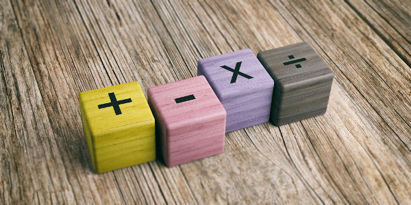 Sinal de mais, menos, vezes e divisão (as quatro operações matemáticas básicas) em blocos de madeira coloridos.