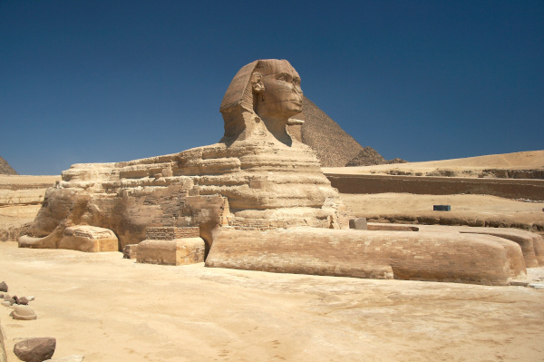 A esfinge de Gizé com a pirâmide de Quéfren ao fundo, um exemplo de escultura egípcia, um dos tipos de arte egípcia.