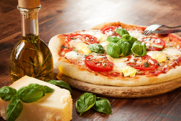 Pizza marguerita sobre uma mesa de madeira, um dos principais sabores de pizza na história da pizza.