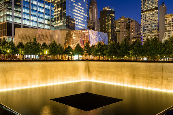 Vista noturna da piscina refletiva Norte com o Memorial do 11 de Setembro ao fundo.[4]