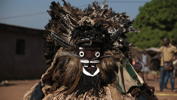Pessoa usando máscara típica da cultura da Costa do Marfim.