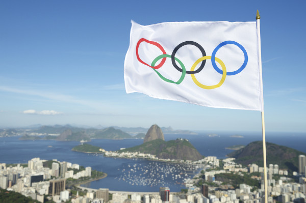 Foto da cidade do Rio de Janeiro e bandeira com os anéis olímpicos.
