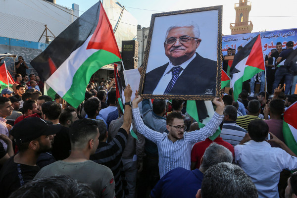 Militante do Fatah segura imagem do presidente do partido e da Autoridade Nacional Palestina, Mahmoud Abbas.[1]