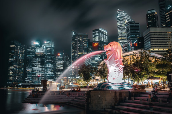 Chafariz em forma de leão próximo a edifícios em Singapura.