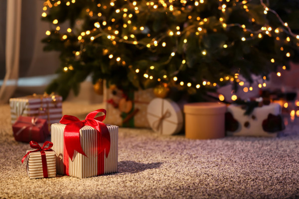 Presentes de Natal, símbolos natalinos que possuem origem incerta, próximos a uma Árvore de Natal.