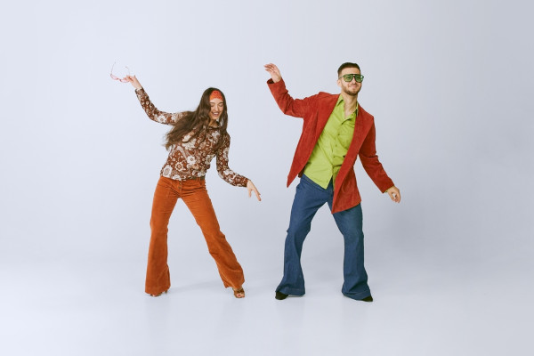 Homem e mulher vestidos de acordo com a moda dos anos 70.