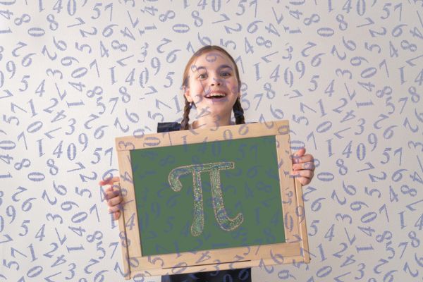 Menina segura um quadro com o símbolo do Pi em alusão ao experimento da olimpíada de matemática da Unicamp