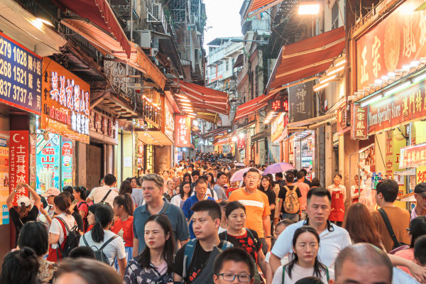 Pessoas circulando por uma rua de Macau, o território mais povoado do mundo.