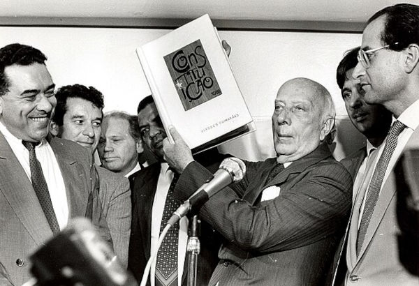 O deputado Ulysses Guimarães segurando a Constituição de 1988, aprovada na Assembleia Constituinte de 1987.