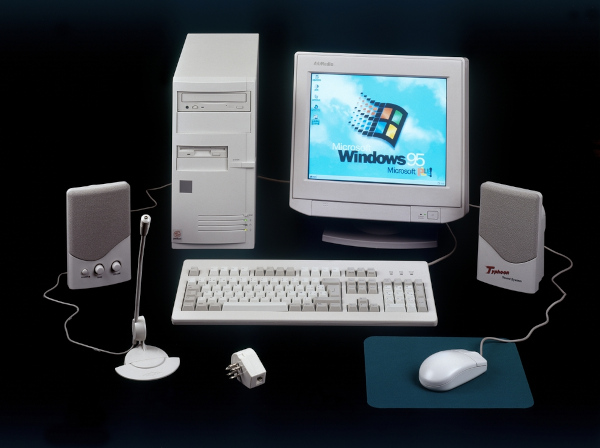 Computador com antigo sistema Windows 95, em texto sobre evolução do computador.