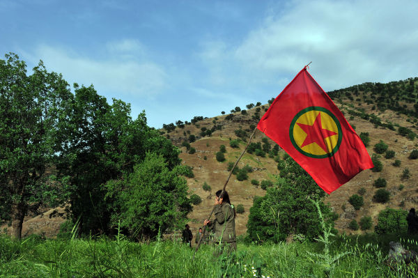 Mulher empunha a bandeira do PKK, o Partido dos Trabalhadores Curdos, que luta pela criação de um Estado nacional.[3]