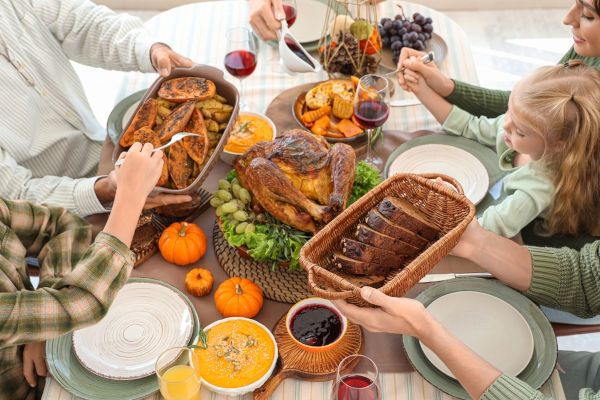 Pessoas compartilhando uma refeição farta no Thanksgiving Day, celebrado na América do Norte.