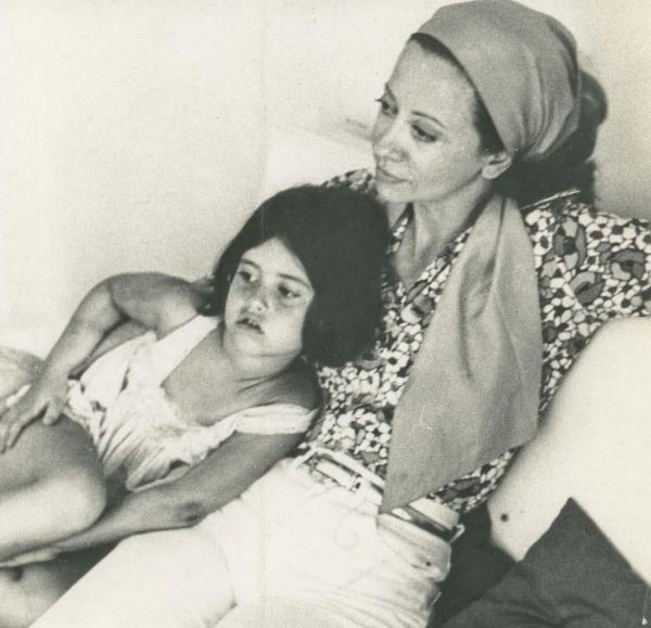 Foto preto e branco de Fernanda Torres ainda criança deitada ao lado de sua mãe, Fernanda Montenegro.