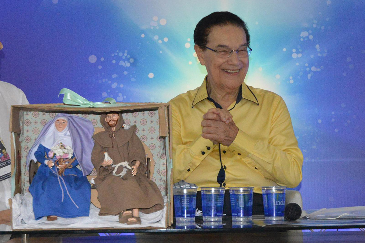 Divaldo Franco sorrindo com imagens de santos