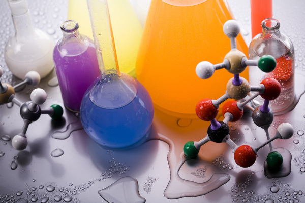 Elementos e vidrarias de laboratório de Química com substâncias, uma alusão à Química Geral.
