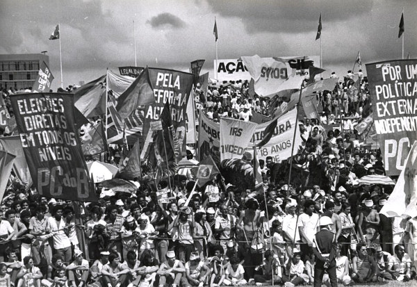 Multidão segurando faixas em protesto pelas Diretas Já, movimento que marcou o fim da Ditadura Militar no Brasil.