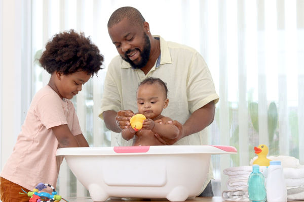 Pai cuidando dos filhos, um exemplo de processo de socialização.