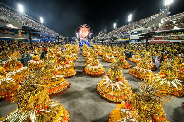 Escola de samba desfilando, parte da história do Carnaval.