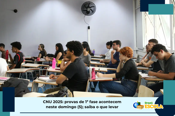 CNU 2025 provas acontecem domingo Foto de pessoas em sala de aplicação prova. Texto: título da notícia.