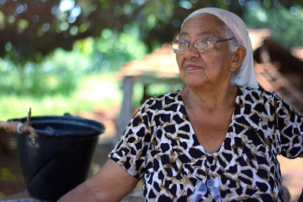 Mulher idosa com lenço no cabelo, em texto sobre envelhecimento populacional no Brasil.