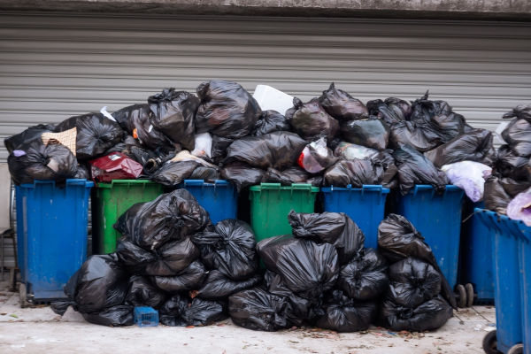 Amontoados de lixo próximos a cestos de lixo. [imagem_principal]