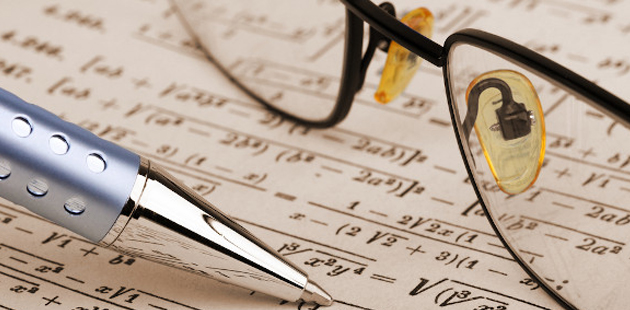 caneta e óculos em cima de equação matemática