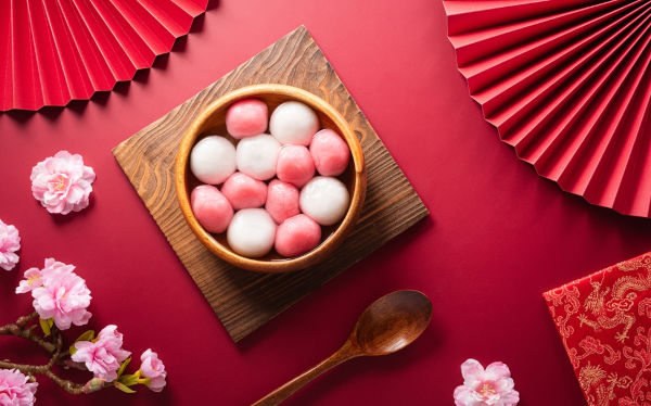 Mesa com decoração chinesa e bolinho de arroz, prato típico do solstício de inverno.