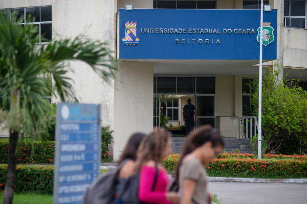 Estudantes caminhando em frente ao prédio da reitoria da UECE, em Fortaleza/CE