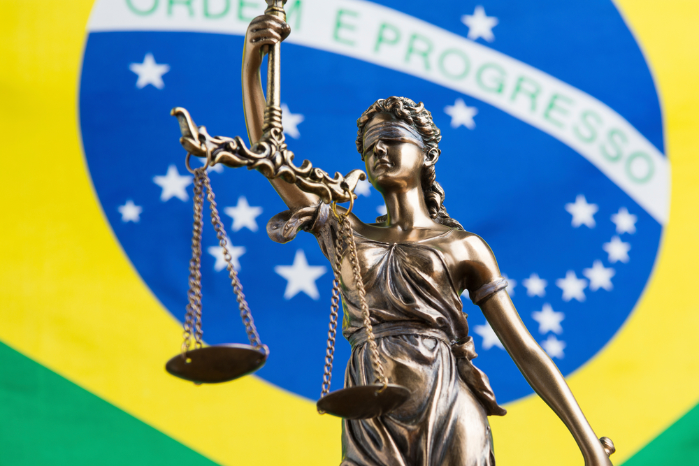 Estátua da justiça à frente da bandeira do Brasil