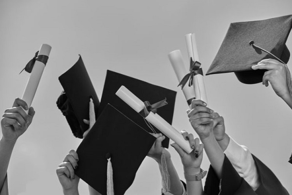 Pessoas se formando segurando diploma e chapéu de formatura nas mãos